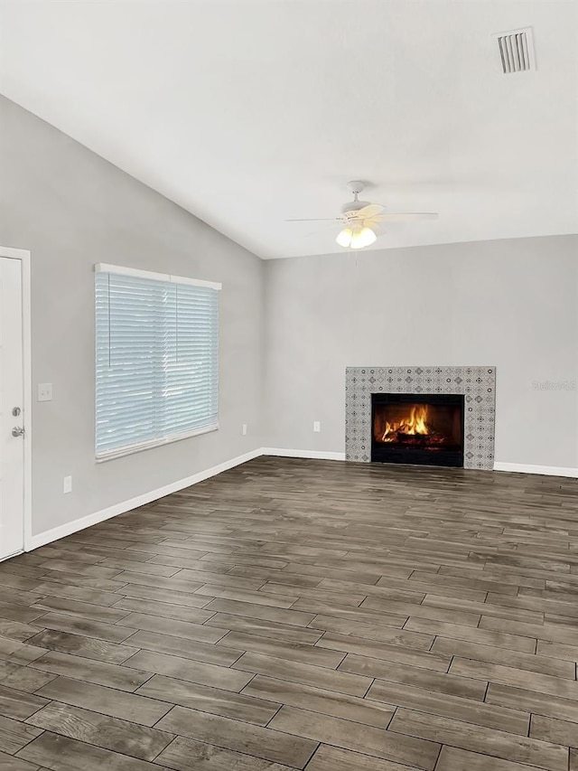 unfurnished living room featuring ceiling fan, a fireplace, and vaulted ceiling