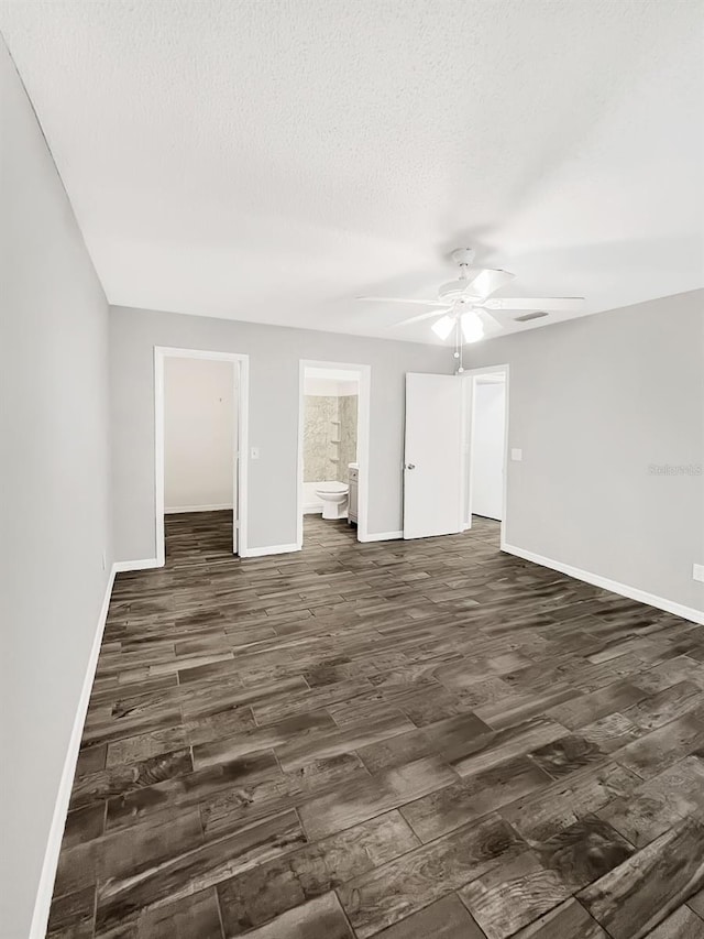 unfurnished room with a textured ceiling, ceiling fan, and dark hardwood / wood-style floors