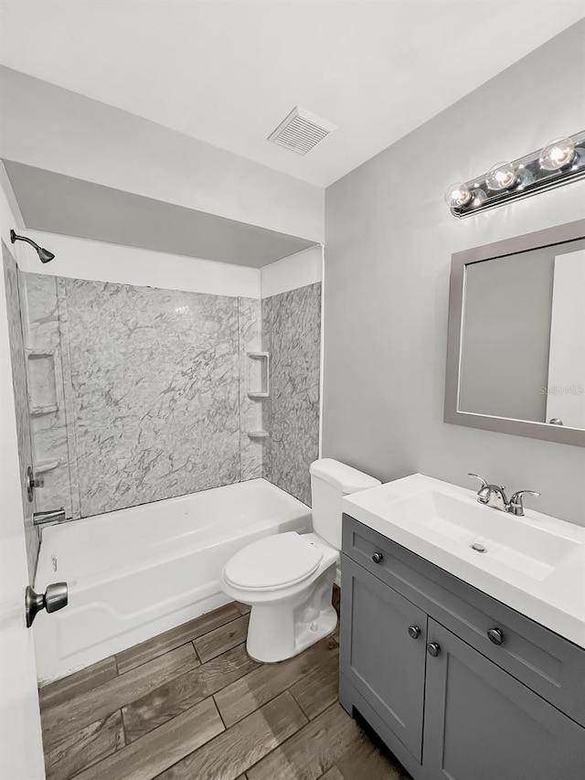 full bathroom featuring tiled shower / bath combo, toilet, and vanity