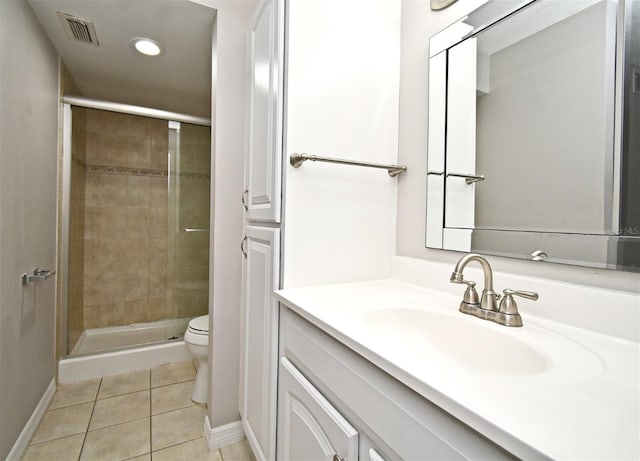 bathroom with tile patterned flooring, vanity, a shower with door, and toilet