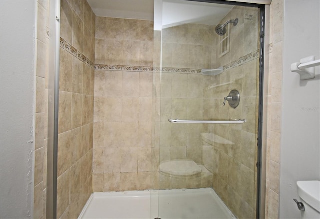 bathroom with a shower with door and toilet