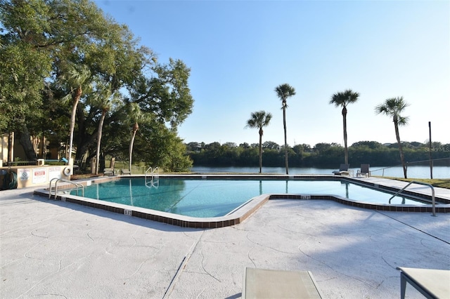 view of pool with a patio area and a water view