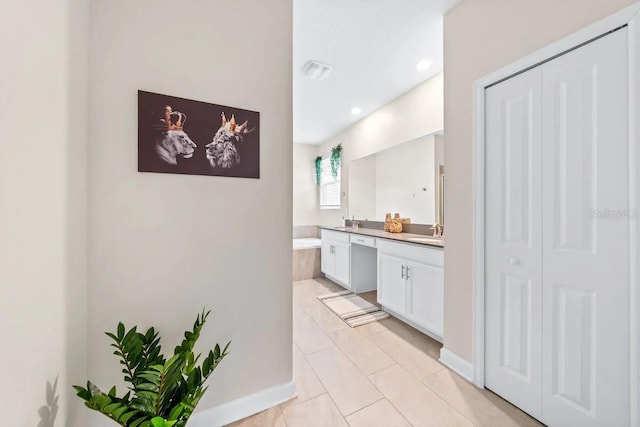 bathroom featuring tiled bath, tile patterned floors, and vanity