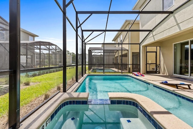 view of pool with glass enclosure and an in ground hot tub