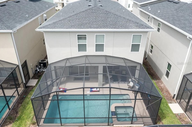 rear view of house with central air condition unit, a lanai, and a patio area