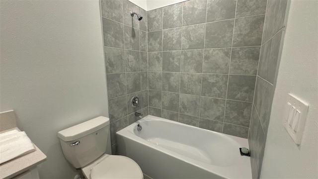 bathroom featuring tiled shower / bath combo and toilet