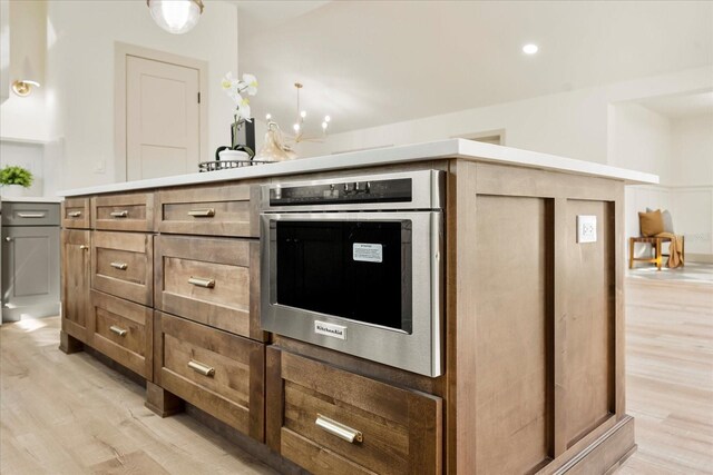 kitchen featuring light countertops, stainless steel oven, and light wood-style floors