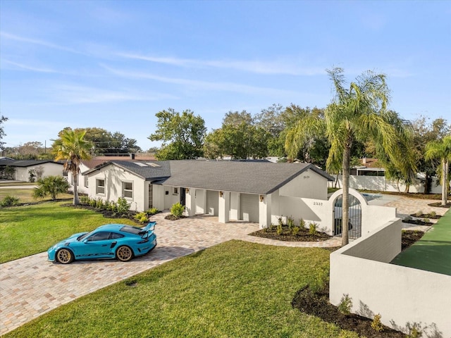 view of front of house with a front lawn, a fenced front yard, a gate, and stucco siding