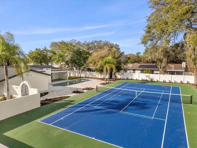 view of tennis court featuring community basketball court and fence