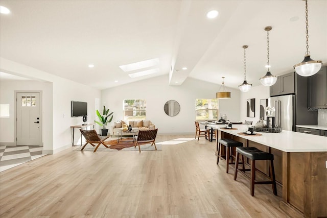 living room with a skylight, baseboards, light wood finished floors, and recessed lighting