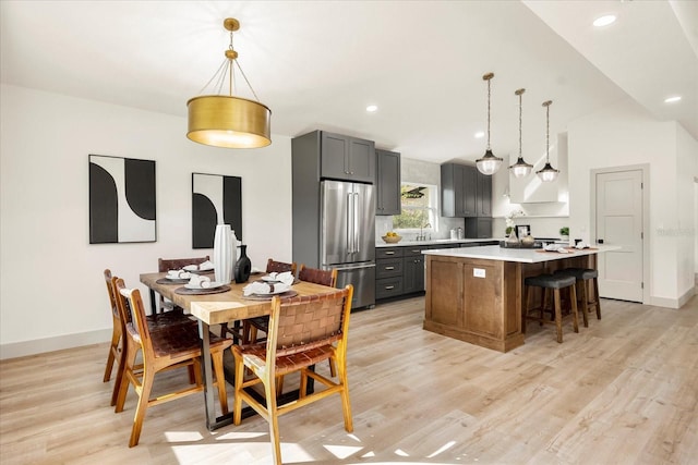dining room with light wood-style floors, baseboards, and recessed lighting