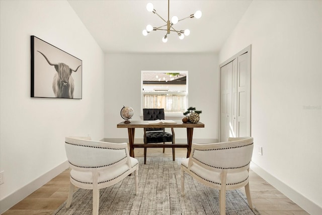 office space featuring a chandelier, wood finished floors, and baseboards