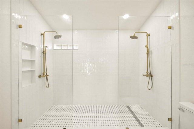 full bath featuring tiled shower and toilet