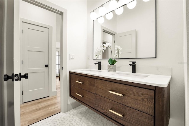 full bath featuring double vanity and baseboards