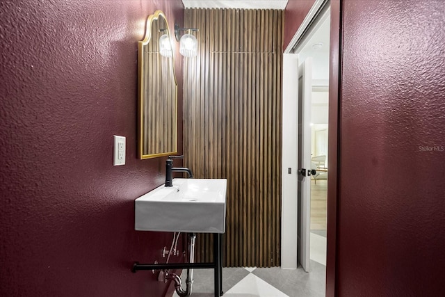 bathroom featuring a sink and a textured wall