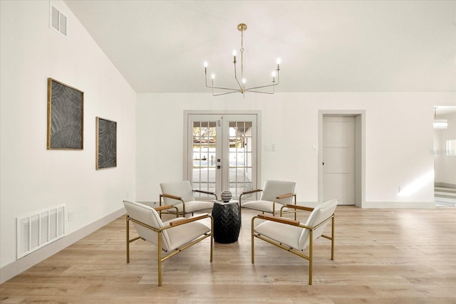 dining area featuring french doors, a chandelier, light wood-style floors, baseboards, and lofted ceiling