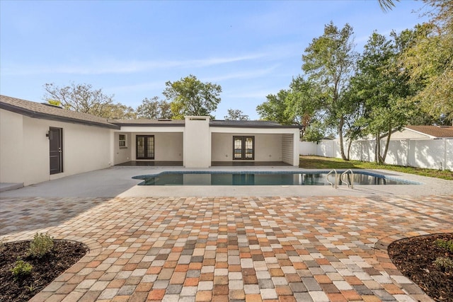view of swimming pool featuring french doors, fence, and a patio area