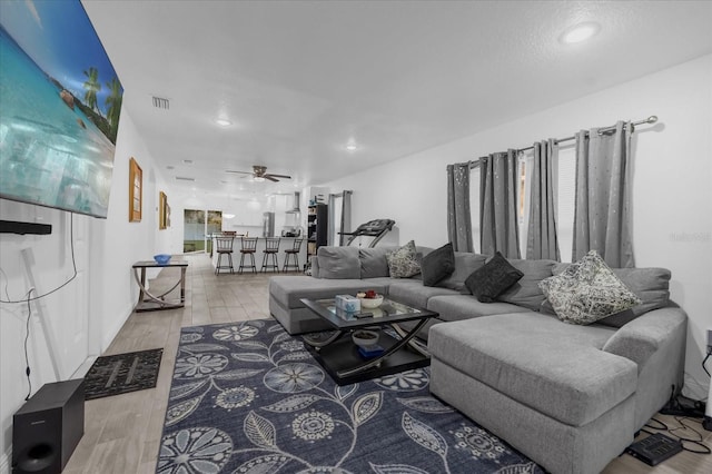 living room featuring ceiling fan and hardwood / wood-style flooring