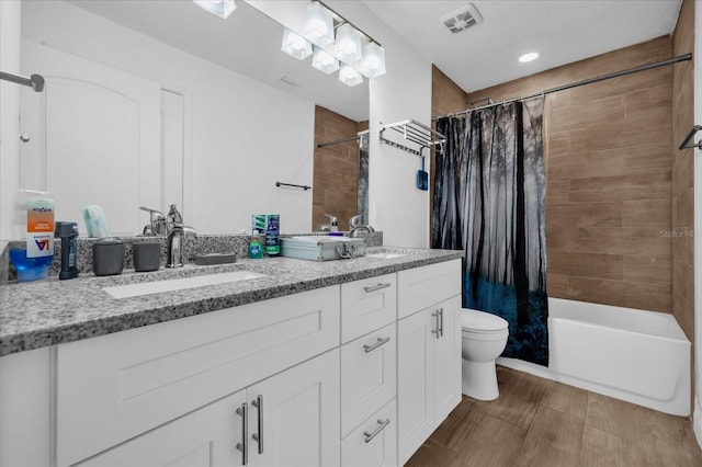 full bathroom featuring vanity, shower / bath combination with curtain, and toilet