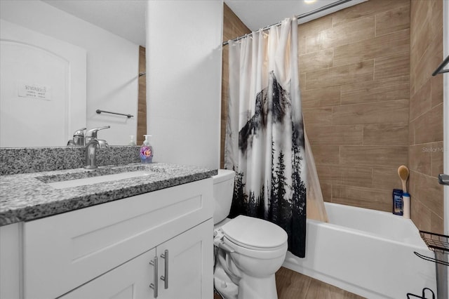 full bathroom featuring hardwood / wood-style floors, vanity, shower / tub combo, and toilet