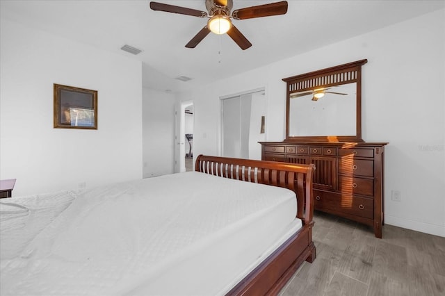 bedroom with ceiling fan, a closet, and light hardwood / wood-style flooring