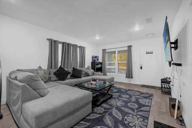 living room featuring visible vents and wood finished floors