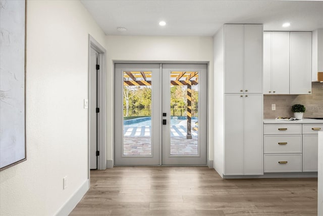 entryway with french doors and light hardwood / wood-style floors