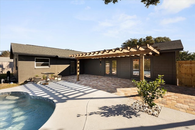 rear view of house with a fenced in pool and a patio area