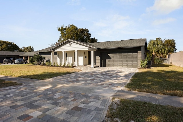 view of front of property featuring a garage, a front yard, and covered porch