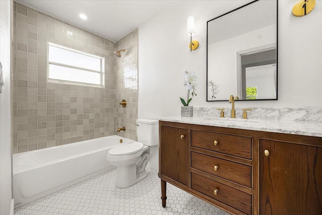 full bathroom featuring tiled shower / bath, vanity, and toilet