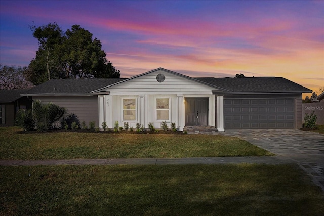 single story home with a garage and a lawn