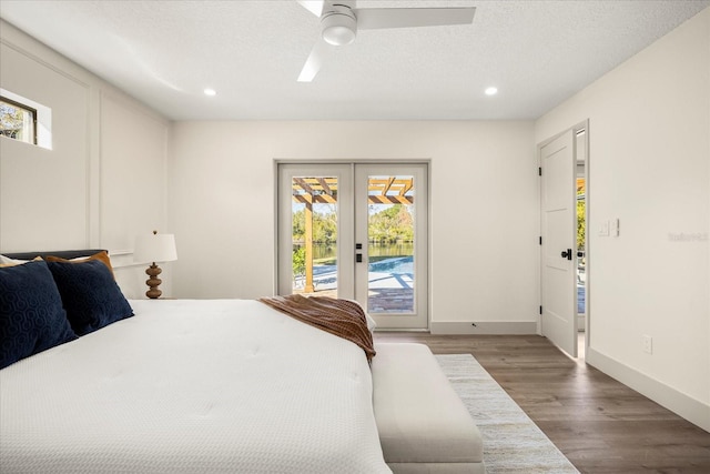 bedroom with hardwood / wood-style flooring, ceiling fan, a textured ceiling, access to outside, and french doors