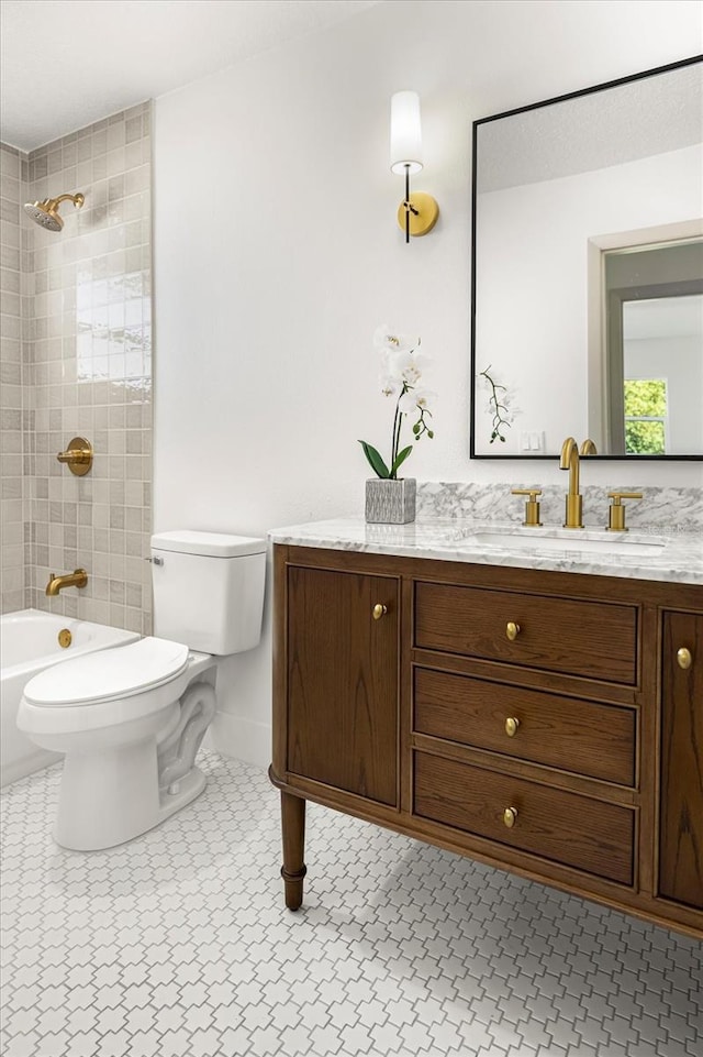 full bathroom featuring tiled shower / bath combo, vanity, tile patterned floors, and toilet