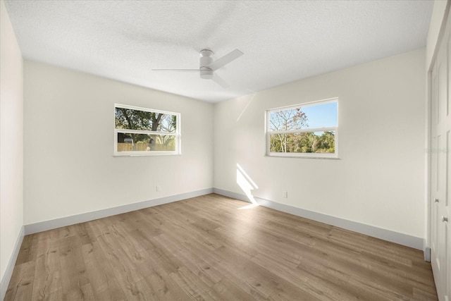 empty room featuring ceiling fan, a textured ceiling, and light wood-type flooring