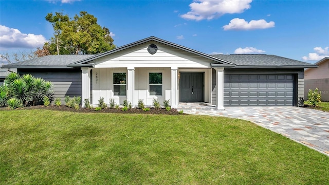 view of front of property featuring decorative driveway, a front yard, an attached garage, and board and batten siding