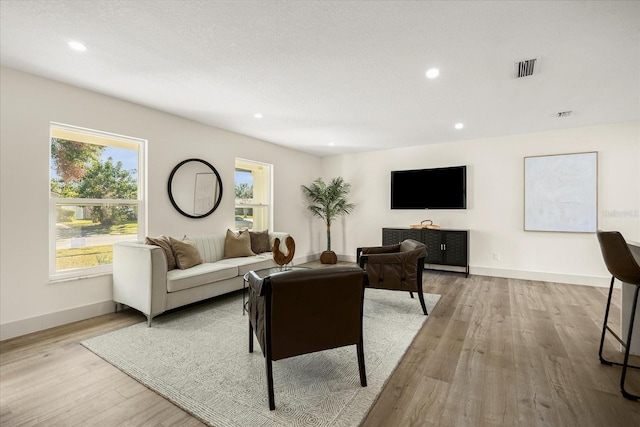 living area featuring recessed lighting, baseboards, wood finished floors, and visible vents
