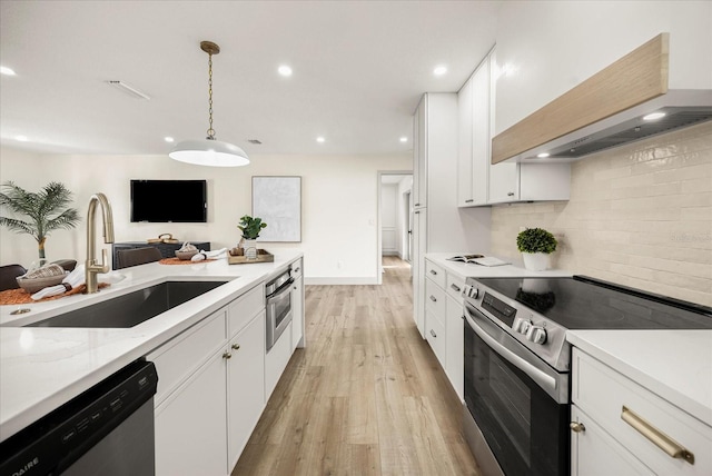 kitchen with white cabinets, appliances with stainless steel finishes, a sink, tasteful backsplash, and custom exhaust hood