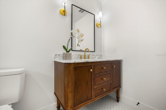 bathroom featuring vanity, baseboards, toilet, and visible vents