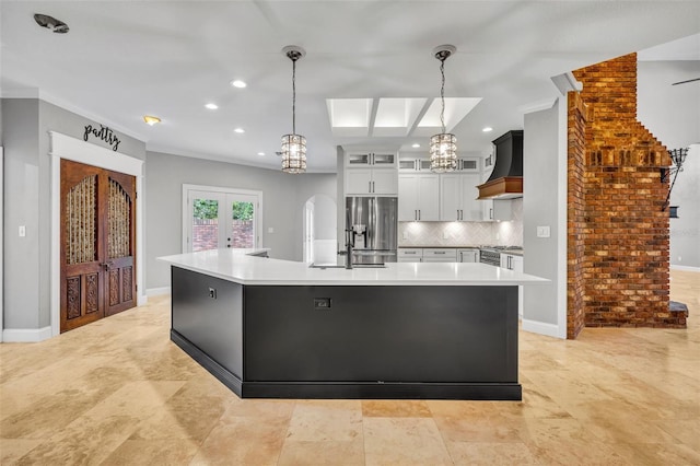 kitchen featuring french doors, stainless steel appliances, crown molding, pendant lighting, and white cabinets