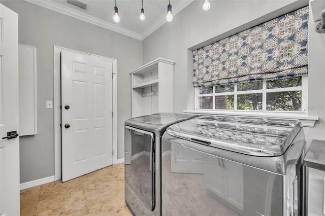 laundry area with washer and dryer and crown molding