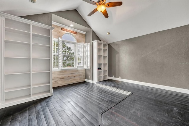 unfurnished living room with dark hardwood / wood-style flooring, vaulted ceiling, and ceiling fan