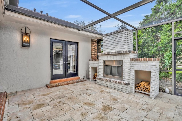 view of patio featuring french doors and an outdoor brick fireplace