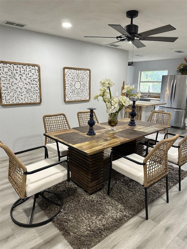 dining space featuring sink, light hardwood / wood-style floors, and ceiling fan