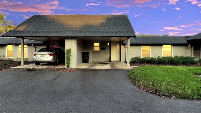 view of front of house with a carport and a lawn