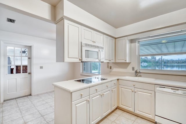 kitchen with white cabinetry, sink, a healthy amount of sunlight, and white appliances