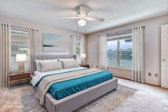 bedroom featuring carpet floors, a water view, and ceiling fan