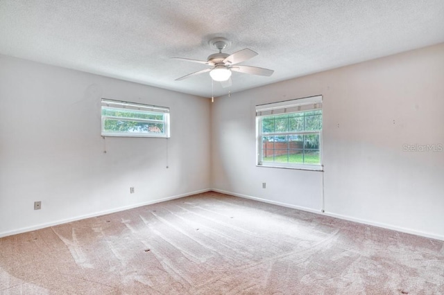 carpeted spare room with ceiling fan and a textured ceiling