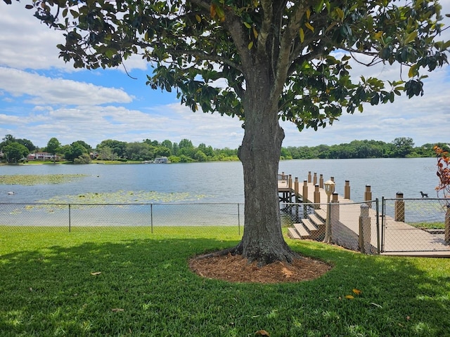 view of dock with a water view and a yard