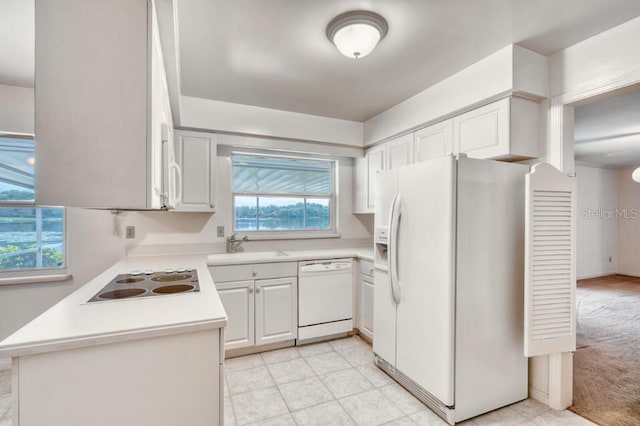 kitchen featuring a wealth of natural light, sink, white cabinets, and white appliances