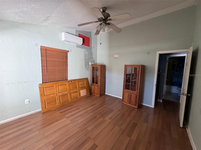 interior space with a wall mounted AC, ceiling fan, a textured ceiling, and hardwood / wood-style flooring